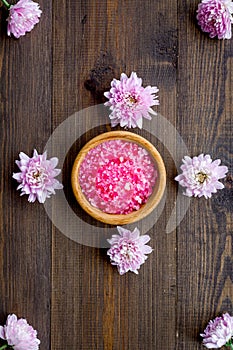 Pink spa salt for aroma therapy with flower fragrance on wooden background top view