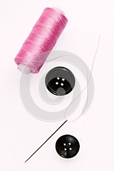 Pink Spool of thread and buttons and needle