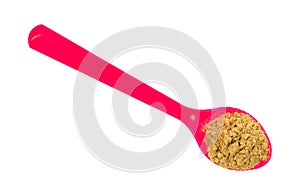 Pink spoon with stir fry seasoning on a white background