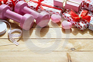 Pink sport dumbbells, heart models and gift boxes on wooden background, Valentines sports background and greeting card any