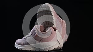 Pink sport shoes spinning on black background. Running shoes, sneakers or trainers. Fitness, sport, training concept.
