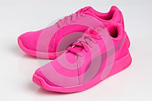 Pink sports running shoes isolated on white background.