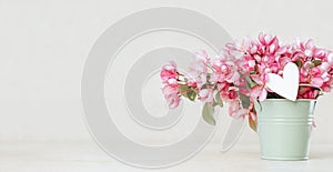 pink spring flowers in a bucket greeting card banner