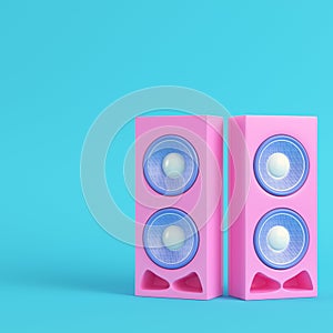 Pink stereo speakers on bright blue background in pastel colors