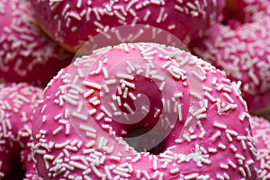 Pink sugarcoated donuts with white sprinkles photo