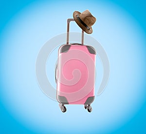 Pink suitcase and hat on blue background. Vignette. Summer minimal creative art poster