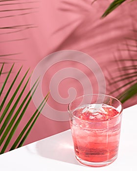 Pink Summer cold alcoholic cocktail on a white bar table