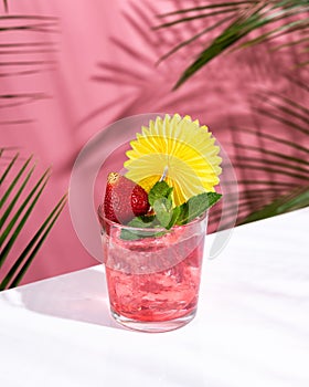 Pink Summer cold alcoholic cocktail on a white bar table
