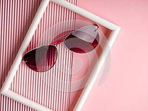 Pink sunglasses on background with copy space, space for text, concept minimalism and modern style