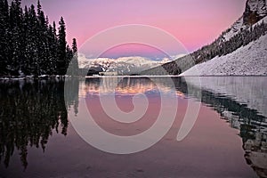 Pink sunrise over alpine lake mountain resort.