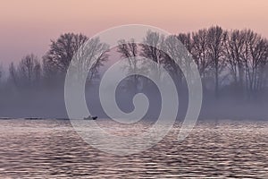 Pink sunset on the Ob River with a floating boat