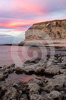 A pink sunset over the limestone cliffs of Port Willunga beach in  South Australia on January 1st 2021