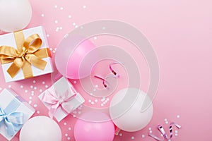 Pink table with balloons, gift or present box and confetti top view. Flat lay. Composition for birthday or party theme.