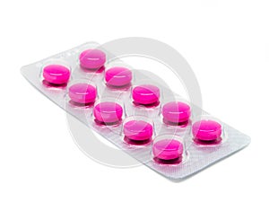 Pink tablets pills in blister pack isolated on white background.