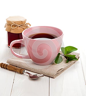 Pink tea cup on white wooden background