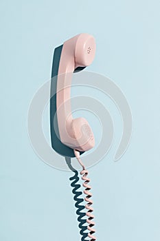 Pink telephone on a blue background.