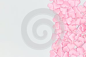 Pink textile hearts confetti on a blue background.