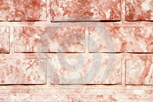 Pink textured brick wall with stains.