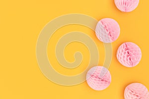 Pink tissue paper balls scattered on a yellow background.