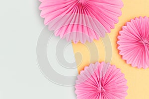 Pink tissue paper fans on a blue background.