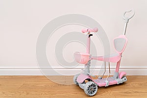 Pink toddler scooter for a baby. Summertime activity for kids.