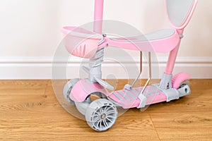 Pink toddler scooter for a baby. Summertime activity for kids.