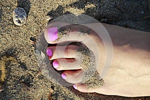 Pink toes resting on the beach