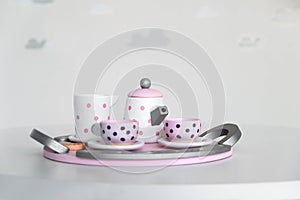 Pink toy mini tea set on gray background. Small toy tea cups and teapot. Coffee set on gray