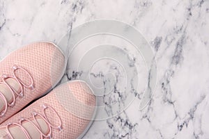 Pink trainers on white marble background