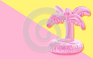 Pink tropical inflatable palm toy on pastel paper background. Trendy minimal summer concept.