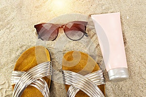 pink tube cream, and sunglasses, slippers. summer beach concept.