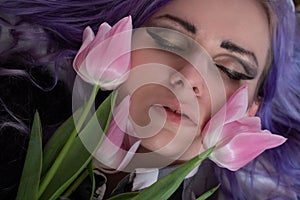 Pink tulips on the background of a woman`s face photo