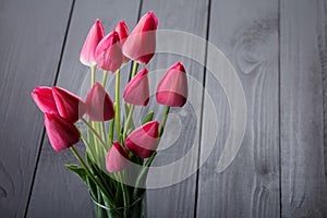 pink tulips on a black wooden table