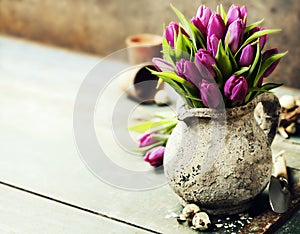 Pink tulips bouquet, easter eggs and garden tools