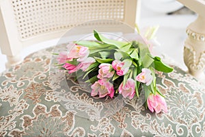 Pink tulips bouquet on vintage chair. Spring card