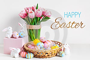 Pink tulips, easter bunnies with colorful eggs in basket, Easter concept