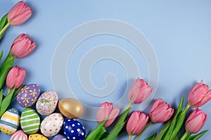Pink tulips flowers and colourful eggs on pink background. Card for Happy Easter