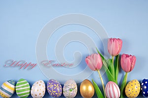 Pink tulips flowers and colourful eggs on pink background. Card for Happy Easter. Waiting for spring