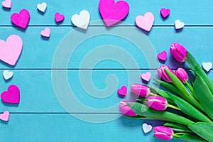 Pink Tulips Flowers and Hearts on blue wooden table for March 8, International Womens Day, Birthday , Valentines Day or Mothers da
