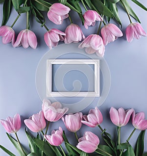 Pink tulips flowers on light blue background with frame for text. Saint Valentines Day frame or background.