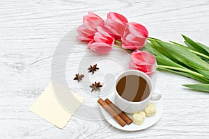 Pink tulips, mug of coffee and cinamon. Empty postcard. Llight w photo