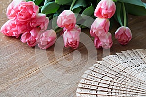 Pink tulips with open hand fan. Wooden board. Tulip. Vintage an