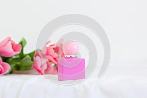 Pink tulips and perfume bottle on white background