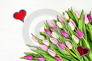 Pink tulips with red hearts on white wooden background. Copy space. Valentine Day, Wedding concept.