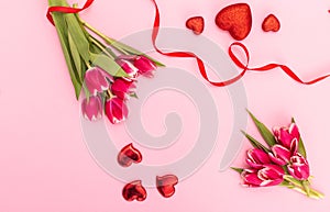 Pink tulips with ribbon and hearts isolated on pink background Valentines day concept