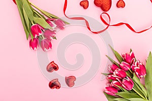 Pink tulips with ribbon and hearts isolated on pink background Valentines day concept