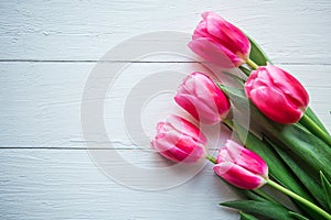 Pink tulips on wooden background. Flat lay, top view, copy space.