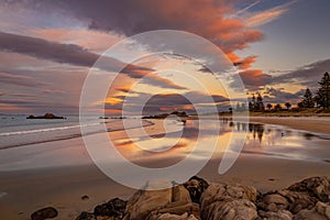 Pink twilight over wet sand beach