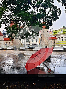 Pink Umbrella on Street cafe wet asphalt  coral  on wet rain drops evening  light   Rainy Autumn relax in Old Town empty ci