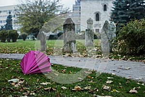 Pink umbrella beside turkish graveyard